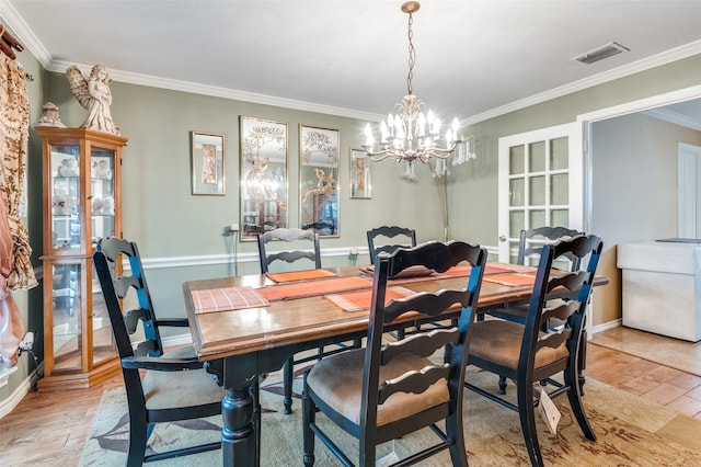 dining room with light hardwood / wood-style floors, a chandelier, and ornamental molding