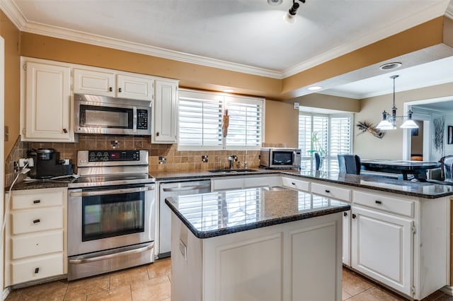 kitchen with appliances with stainless steel finishes, white cabinetry, and a kitchen island