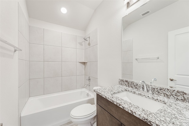 full bathroom with tiled shower / bath, vanity, and toilet