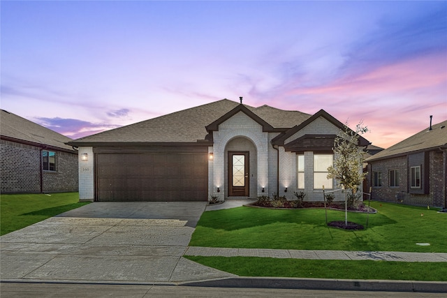 view of front of property featuring a yard and a garage