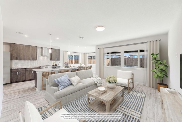 living room with sink and light hardwood / wood-style floors