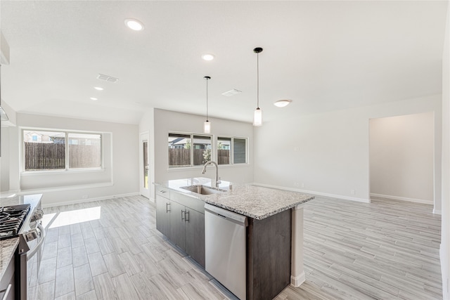 kitchen featuring appliances with stainless steel finishes, sink, pendant lighting, and light wood-type flooring