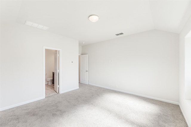 unfurnished room featuring light carpet and lofted ceiling