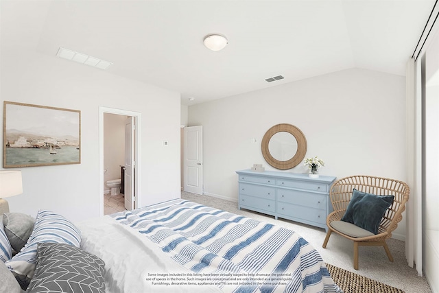 bedroom featuring light colored carpet, ensuite bathroom, and vaulted ceiling