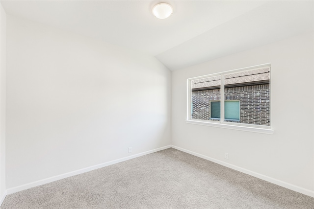 carpeted empty room featuring lofted ceiling