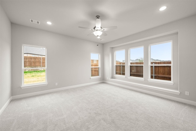 carpeted spare room featuring ceiling fan