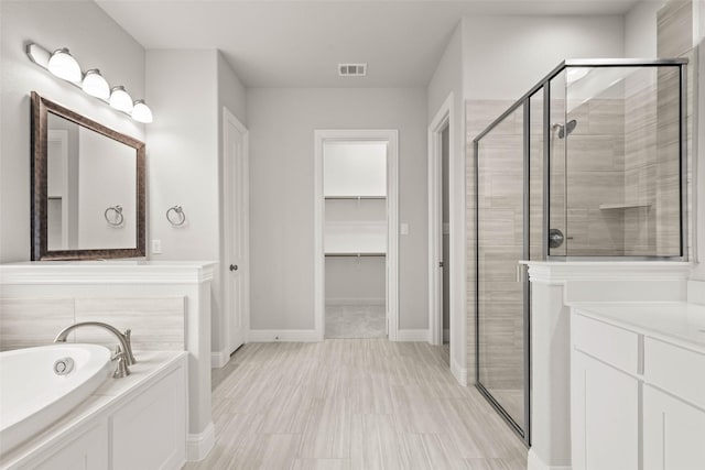 bathroom with vanity and shower with separate bathtub