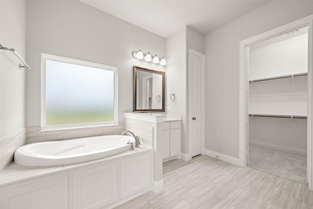 bathroom featuring vanity and a washtub