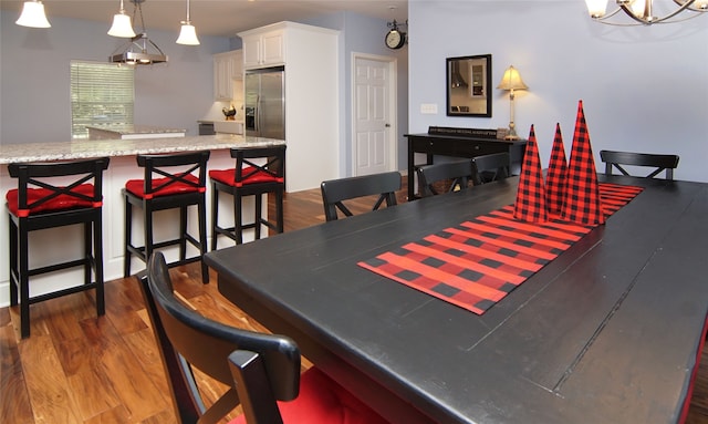 dining room featuring dark wood-type flooring and an inviting chandelier