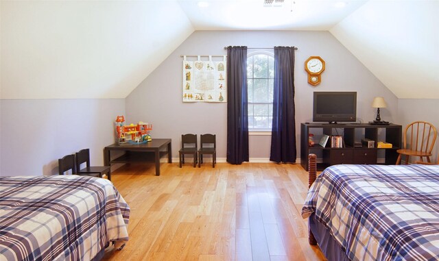 bedroom with lofted ceiling and light wood-type flooring