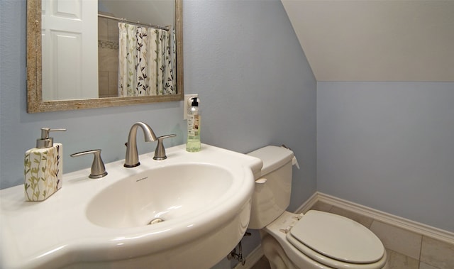 bathroom with sink, toilet, tile patterned floors, and vaulted ceiling