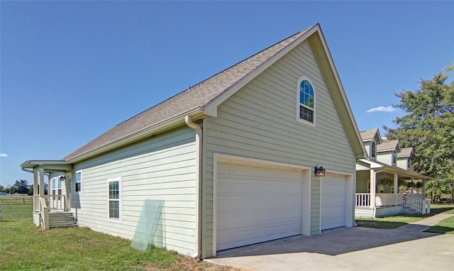 view of property exterior with a garage, a porch, and a lawn