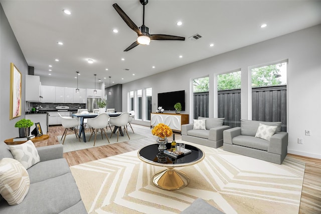 living room featuring ceiling fan and light wood-type flooring