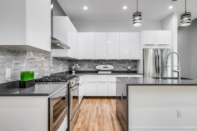 kitchen featuring stainless steel appliances, sink, pendant lighting, and white cabinets