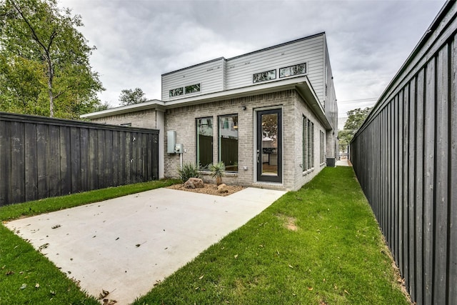 rear view of property with a yard and a patio area