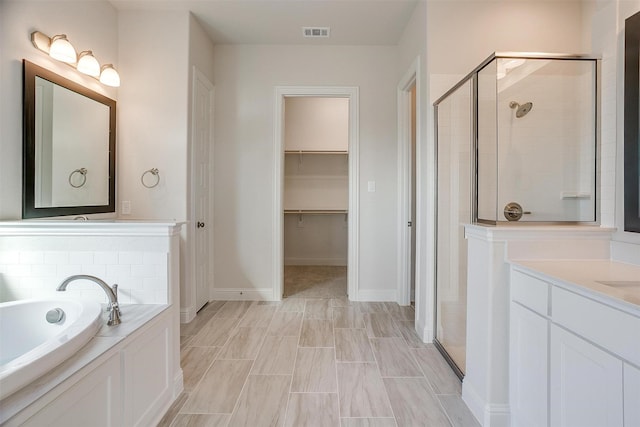 bathroom featuring vanity and plus walk in shower