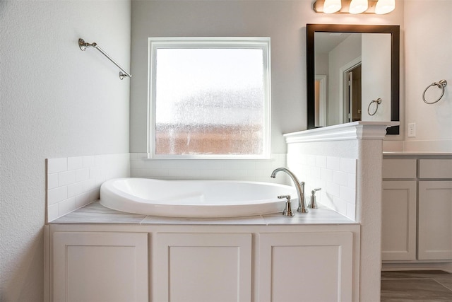 bathroom with vanity and a bath