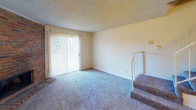 living room featuring carpet, a brick fireplace, brick wall, and a textured ceiling