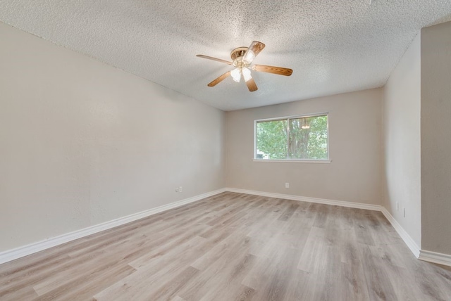 empty room featuring ceiling fan, light hardwood / wood-style flooring, and a textured ceiling