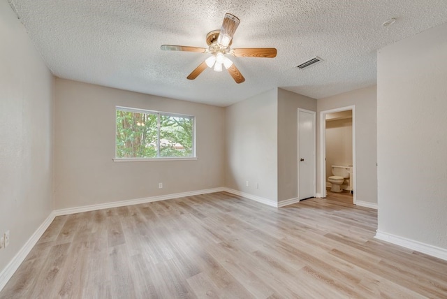 empty room with ceiling fan, a textured ceiling, and light wood-type flooring