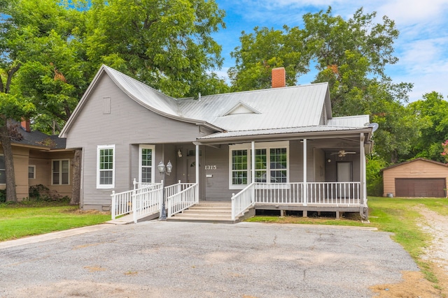 view of front of home with a porch, a front lawn, and an outbuilding