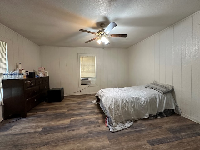 bedroom featuring ceiling fan, multiple windows, a textured ceiling, and dark hardwood / wood-style flooring