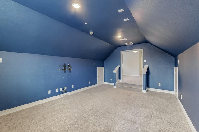 bonus room with vaulted ceiling, carpet, and a textured ceiling