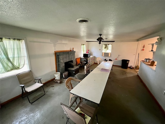 interior space with ceiling fan, cooling unit, a textured ceiling, and concrete floors