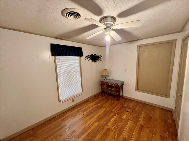 unfurnished room featuring a textured ceiling, light hardwood / wood-style floors, and ceiling fan