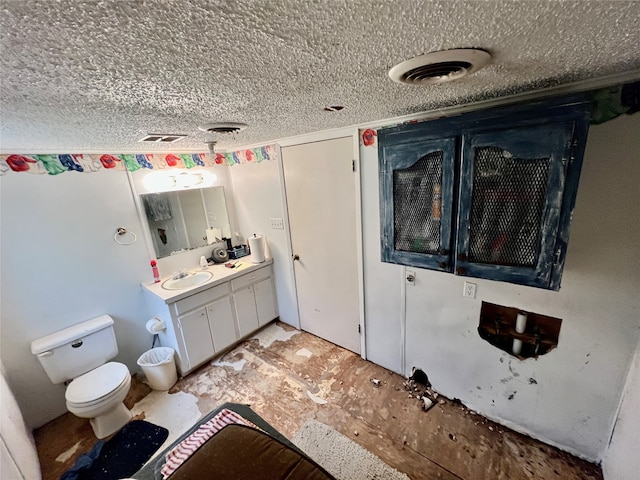 bathroom featuring vanity, a textured ceiling, and toilet