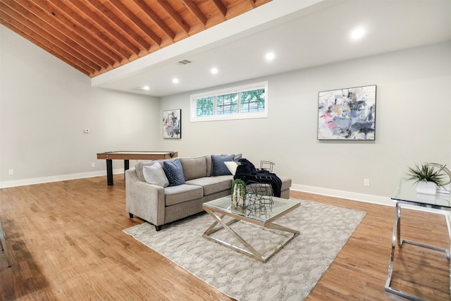 living room featuring beamed ceiling and light hardwood / wood-style flooring