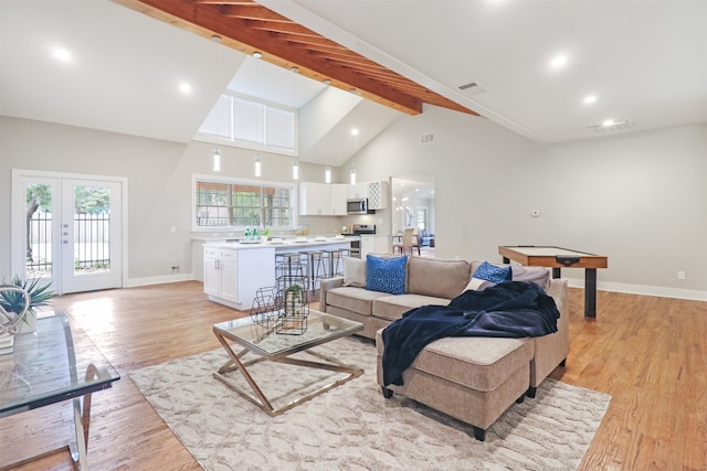 living room with beam ceiling, french doors, light wood-type flooring, and high vaulted ceiling