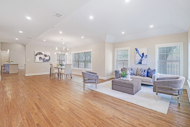 living room featuring light wood-type flooring and a notable chandelier