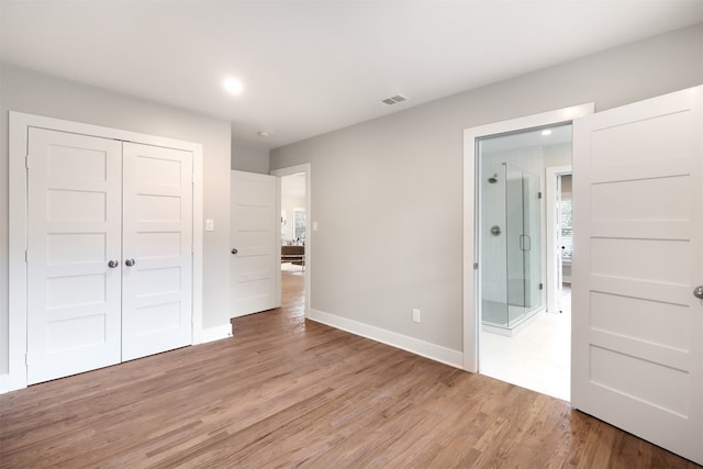 unfurnished bedroom with light hardwood / wood-style flooring and a closet