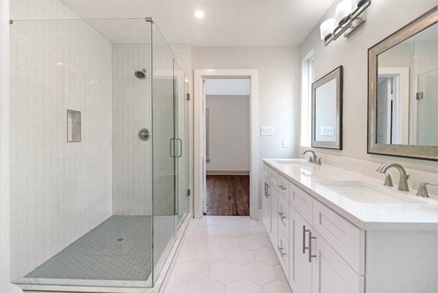 bathroom with an enclosed shower, hardwood / wood-style flooring, and dual bowl vanity