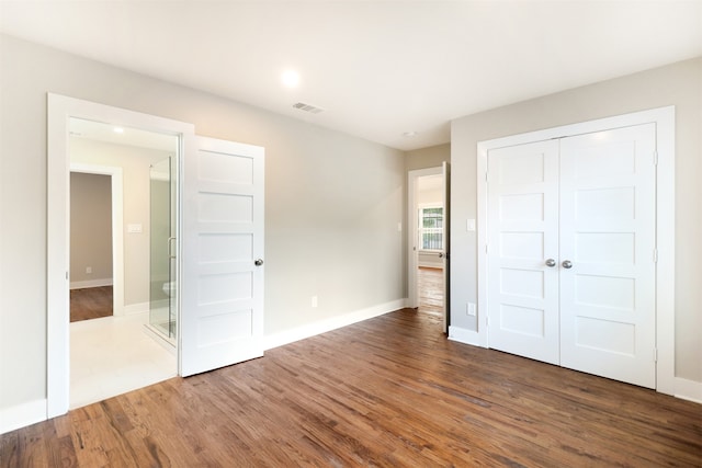 unfurnished bedroom featuring a closet and hardwood / wood-style floors