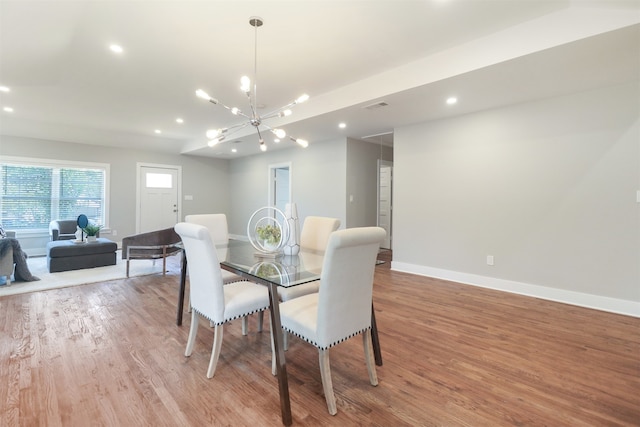 dining space featuring a notable chandelier and light wood-type flooring