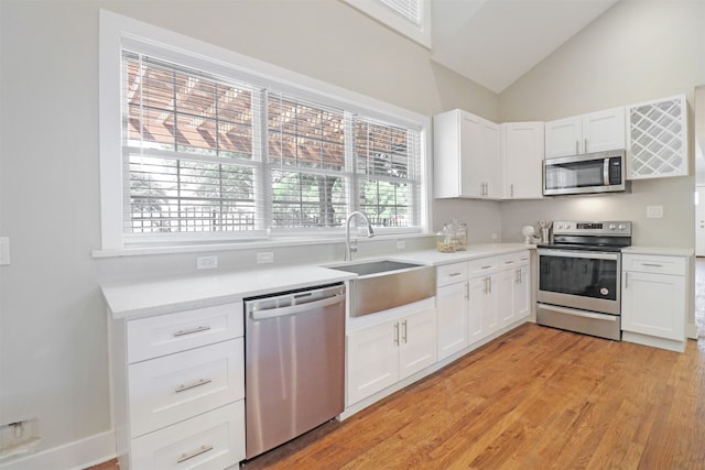 kitchen featuring sink, white cabinetry, light wood-type flooring, and stainless steel appliances