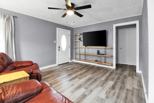 living room featuring ceiling fan, hardwood / wood-style flooring, and a textured ceiling