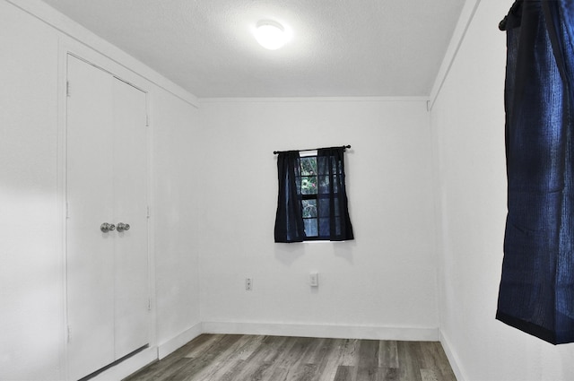 spare room featuring light hardwood / wood-style floors and a textured ceiling