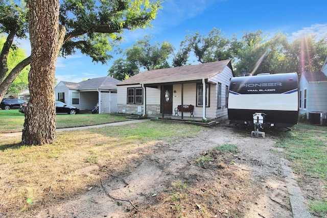 view of front of property with central AC and a front lawn