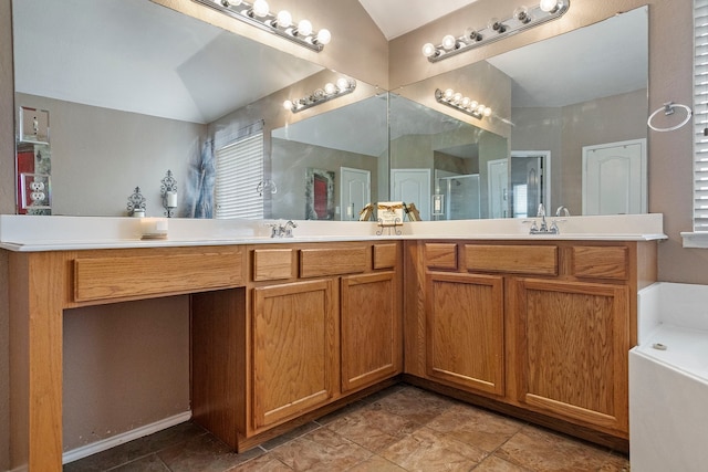 bathroom with tile patterned floors, lofted ceiling, a bath, and double vanity