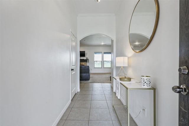 hall with light tile patterned flooring and ornamental molding