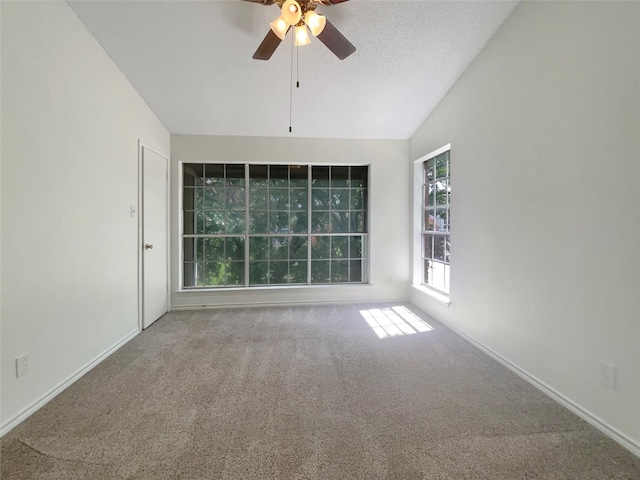 empty room featuring ceiling fan, carpet floors, and vaulted ceiling