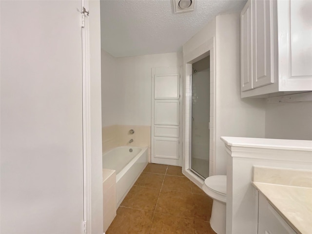 full bathroom featuring tile patterned flooring, separate shower and tub, vanity, a textured ceiling, and toilet