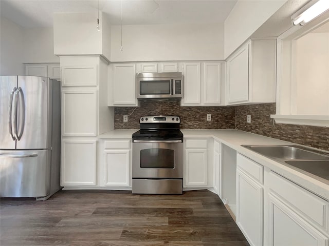 kitchen featuring dark hardwood / wood-style flooring, white cabinetry, backsplash, and stainless steel appliances