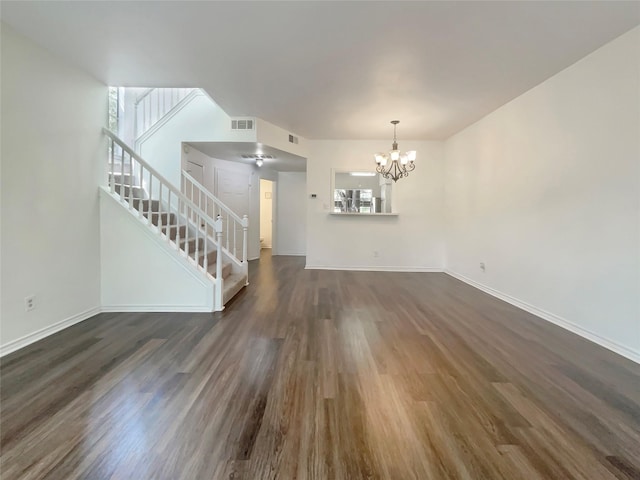 unfurnished living room featuring dark hardwood / wood-style floors and a chandelier