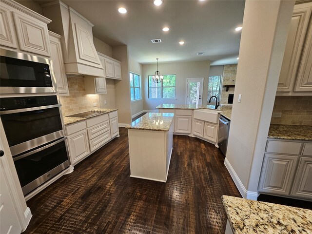 kitchen with appliances with stainless steel finishes, white cabinetry, and light stone counters