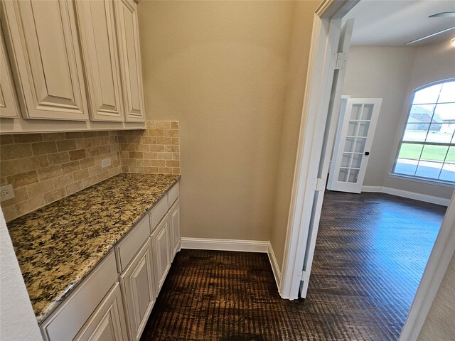 kitchen featuring light stone counters, white cabinetry, tasteful backsplash, and dark hardwood / wood-style flooring