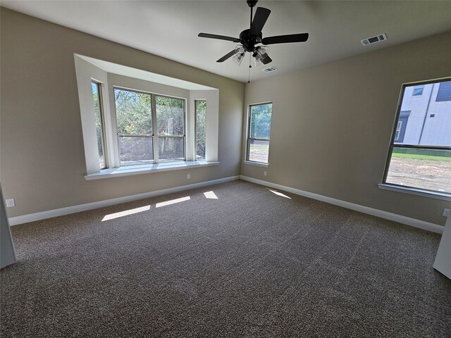 unfurnished room featuring dark colored carpet and ceiling fan